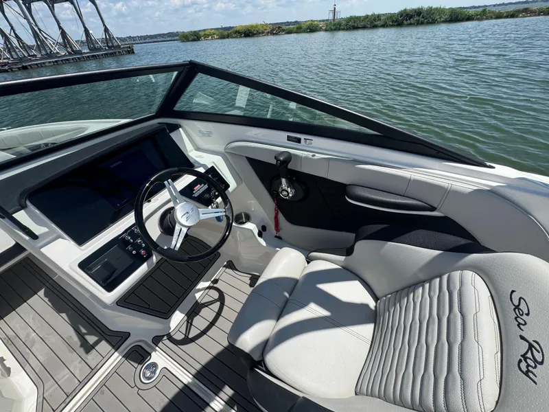 Slide: The Image of 2023 Sea Ray SPX 190 boat interior with steering wheel and dashboard on a sunny day. - 11