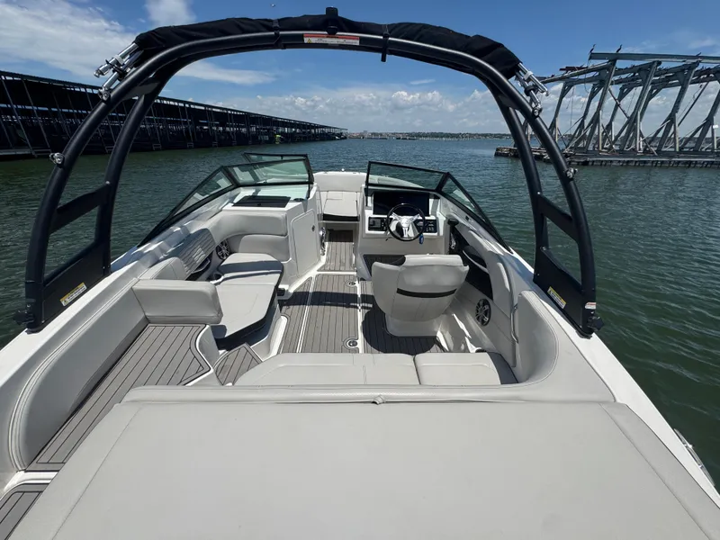 Slide: The Image of 2023 Sea Ray SPX 190 boat interior with seating and steering, docked on a sunny day. - 15