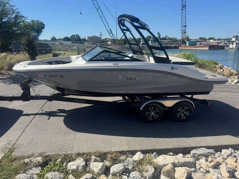 Slide: The Image of 2023 Sea Ray SPX 190 boat on trailer, parked near waterfront with industrial background. - 20