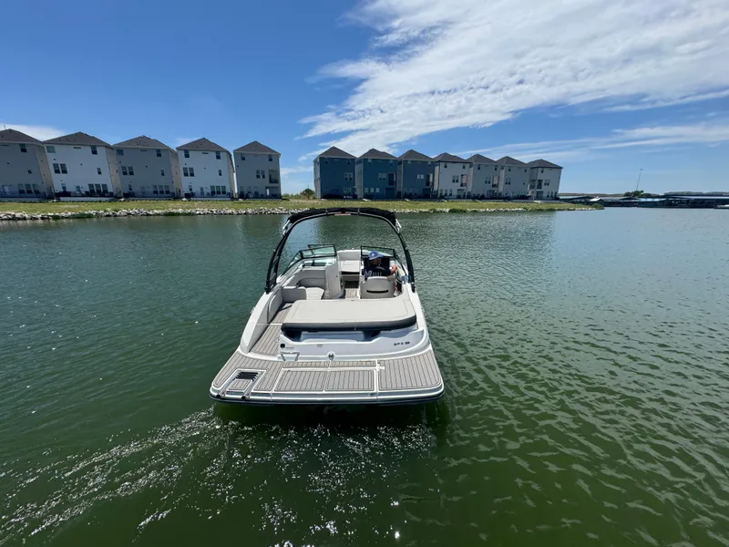 Slide: The Image of 2023 Sea Ray SPX 190 boat on calm water near waterfront homes under a blue sky. - 5