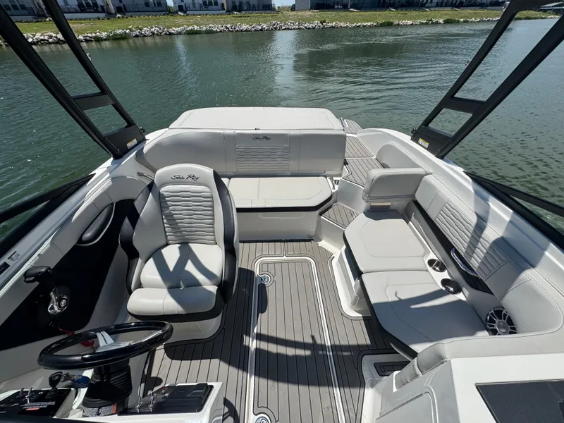 Slide: The Image of 2023 Sea Ray SPX 190 boat interior with sleek seating and modern design on calm water. - 9