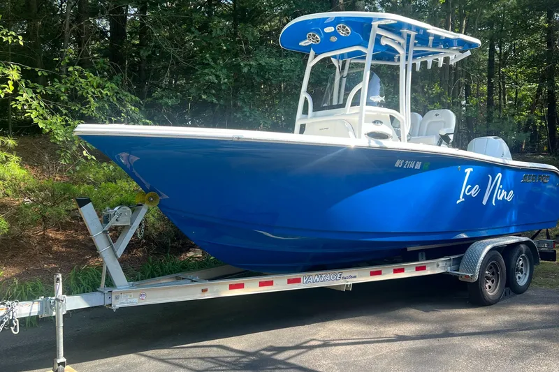 Slide: The Image of 2021 Sea Pro 219 Center Console boat on trailer in wooded area. - 0