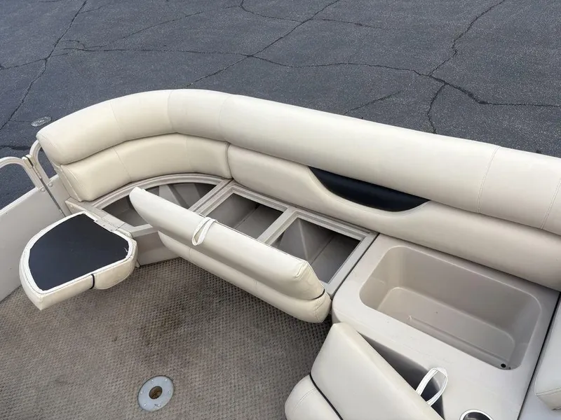 Slide: The Image of 2006 Sylvan 8522 Signature boat interior with beige seating and storage compartments. - 11
