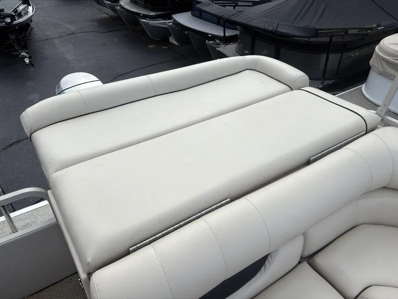 Slide: The Image of 2006 Sylvan 8522 Signature boat with beige cushioned seating, docked alongside other boats. - 15