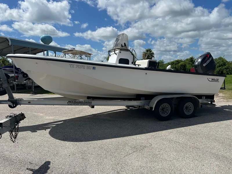 Slide: The Image of 1989 Boston Whaler 23 Guardian boat on trailer under a partly cloudy sky. - 15