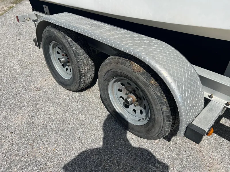 Slide: The Image of Trailer wheels of a 1989 Boston Whaler 23 Guardian on asphalt. - 2