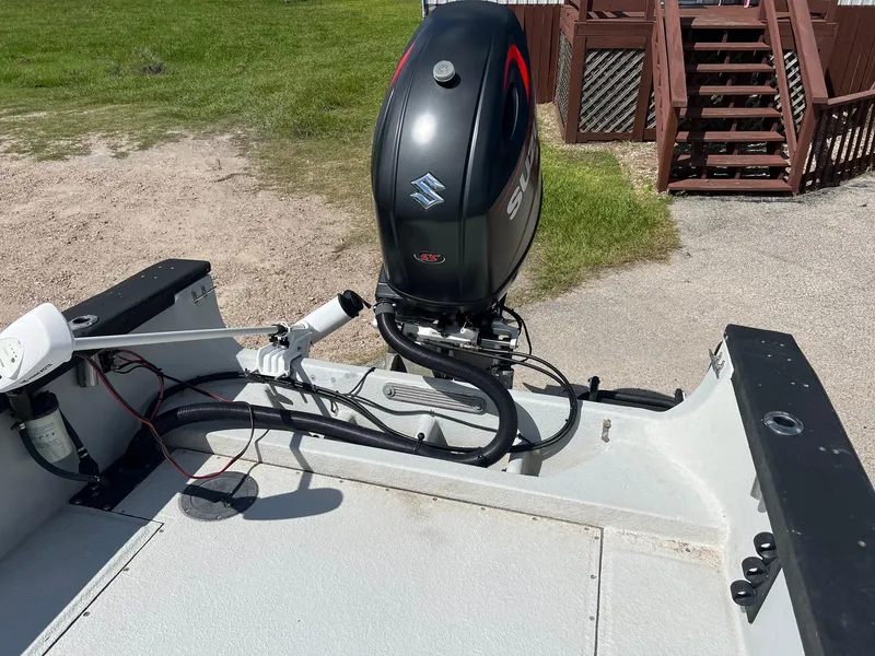 Slide: The Image of 1989 Boston Whaler 23 Guardian boat with Suzuki outboard motor, parked near wooden stairs. - 7