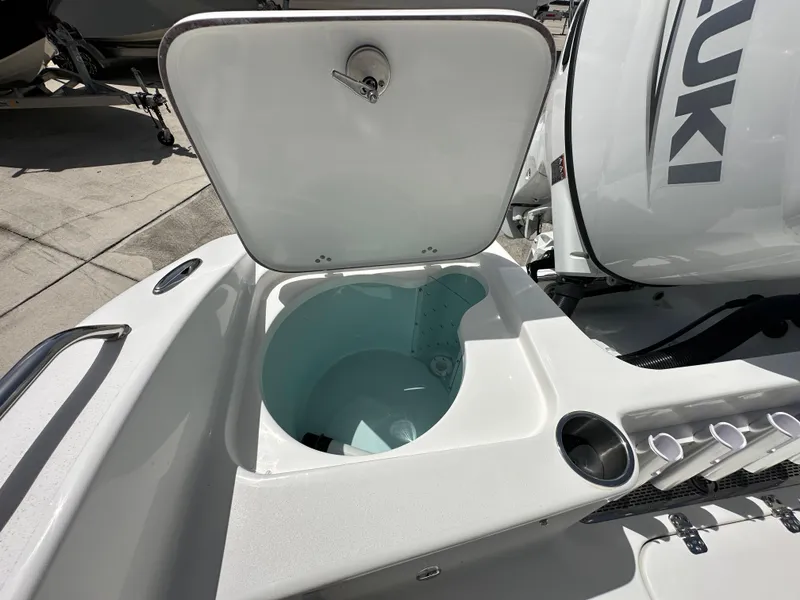 Slide: The Image of 2026 Sea Pro 202 Center Console livewell and storage compartment, open lid, Suzuki engine visible. - 11