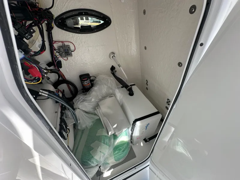 Slide: The Image of Interior view of 2026 Sea Pro 202 Center Console boat's storage compartment with wiring and equipment. - 8