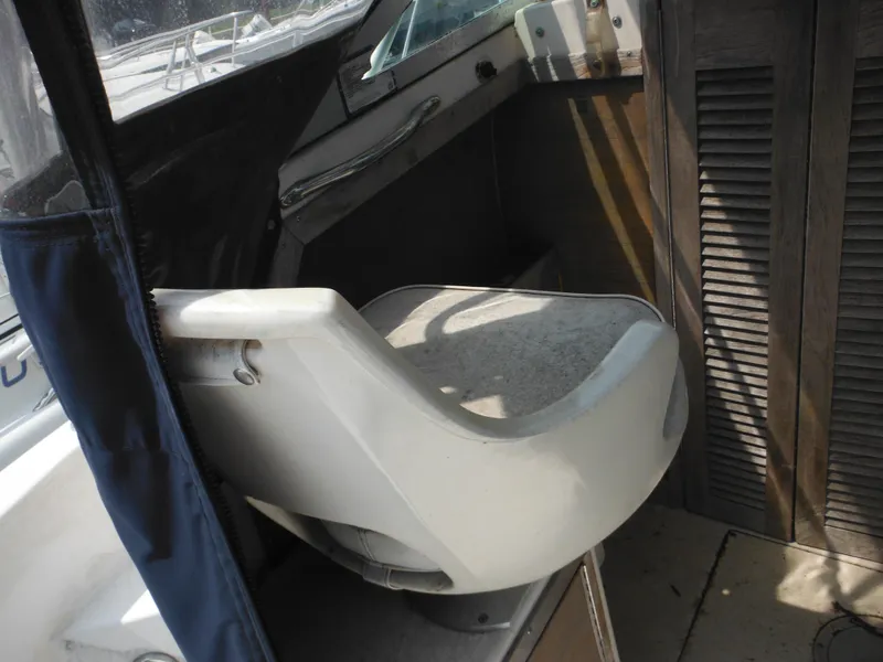 Slide: The Image of 1988 Grady-White Offshore 240 boat interior with a white captain's chair and wooden paneling. - 10