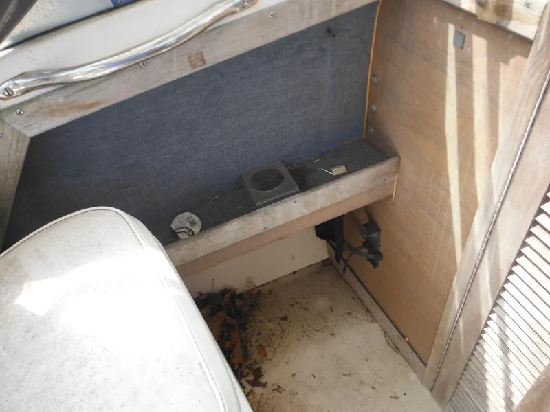 Slide: The Image of 1988 Grady-White Offshore 240 interior, showing storage area with wooden and fabric elements. - 16