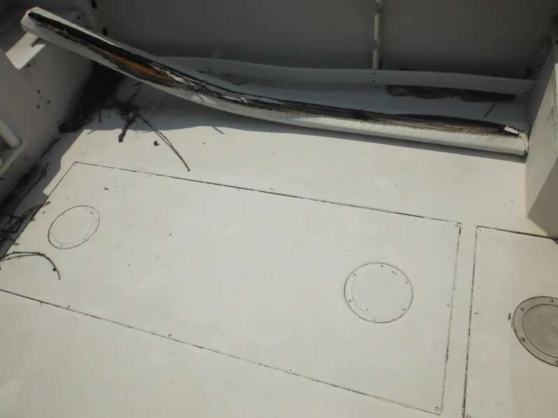 Slide: The Image of 1988 Grady-White Offshore 240 boat deck with storage compartments and visible wear. - 27