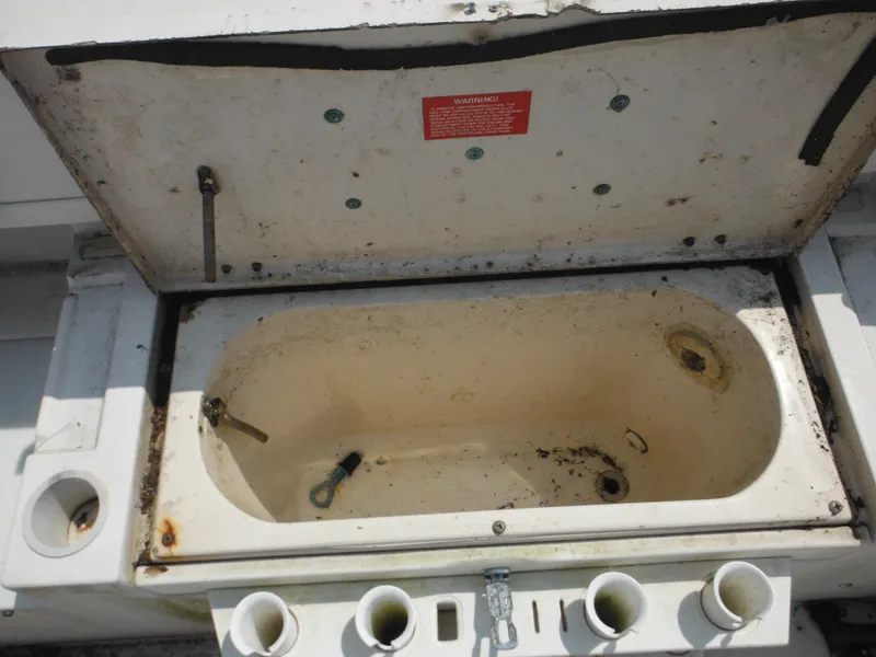 Slide: The Image of Open storage compartment on 1988 Grady-White Offshore 240 boat, showing wear and rust. - 30
