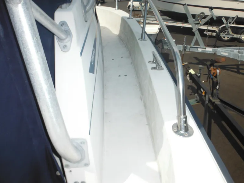 Slide: The Image of 1988 Grady-White Offshore 240 boat deck with metal railings and trailer in background. - 39