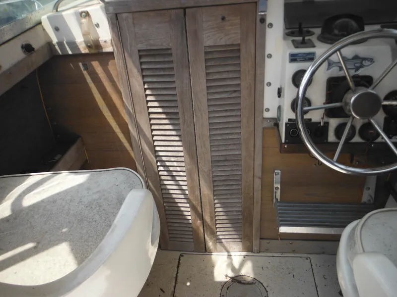 Slide: The Image of 1988 Grady-White Offshore 240 boat interior with wooden paneling and steering wheel. - 47