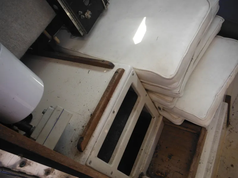 Slide: The Image of Interior of 1988 Grady-White Offshore 240 boat with white cushions and storage compartments. - 49