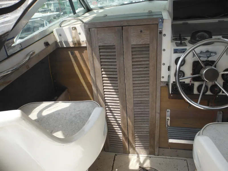 Slide: The Image of 1988 Grady-White Offshore 240 boat interior with steering wheel and wooden cabinet. - 8