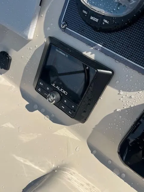 Slide: The Image of JL Audio system on 2024 Boston Whaler 210 Montauk boat dashboard with water droplets. - 10