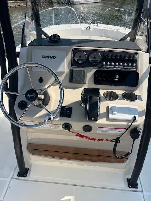 Slide: The Image of 2024 Boston Whaler 210 Montauk boat console with steering wheel and navigation controls. - 13