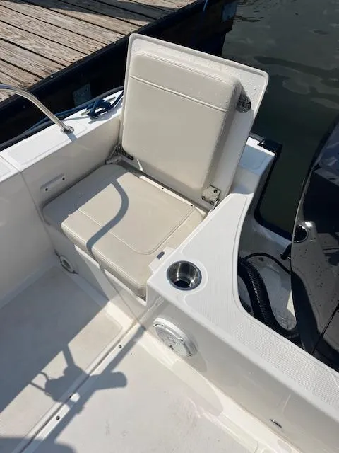 Slide: The Image of 2024 Boston Whaler 210 Montauk boat seat with cup holder, dockside view. - 14