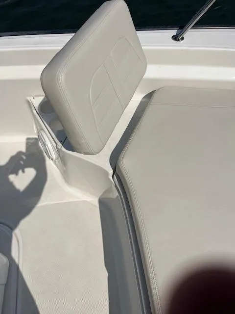 Slide: The Image of 2024 Boston Whaler 210 Montauk boat interior with white cushioned seating. - 16