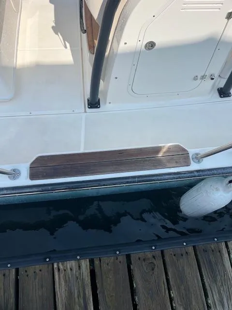 Slide: The Image of 2024 Boston Whaler 210 Montauk boat docked, showing deck and fender. - 5