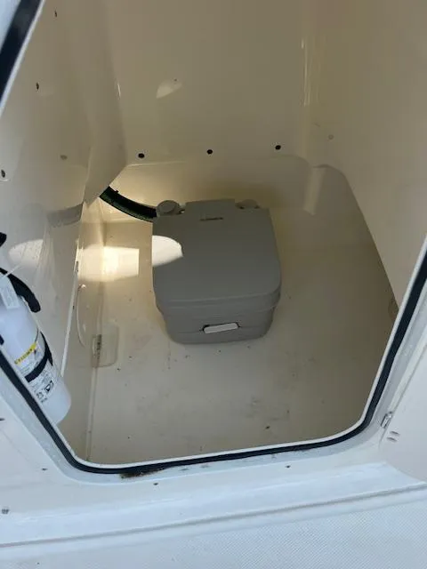 Slide: The Image of 2024 Boston Whaler 210 Montauk interior with portable toilet and storage space. - 7