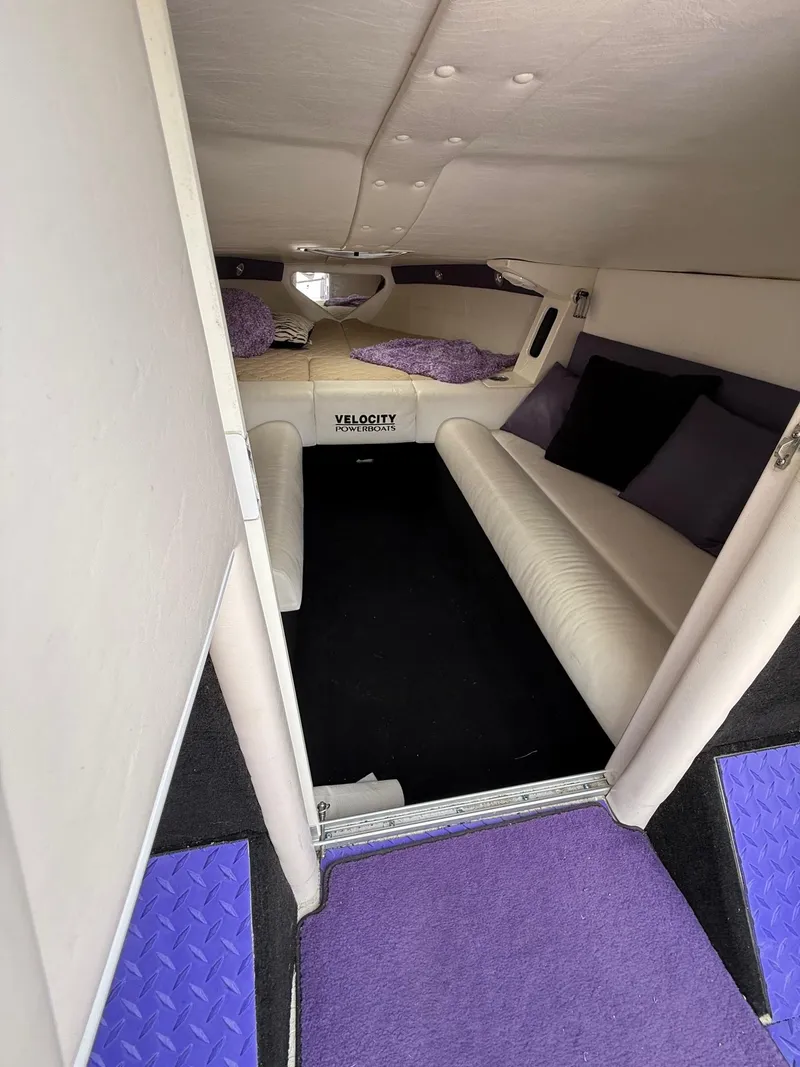 Slide: The Image of Interior of a 2006 Velocity VR1 boat with cozy seating and purple accents. - 14