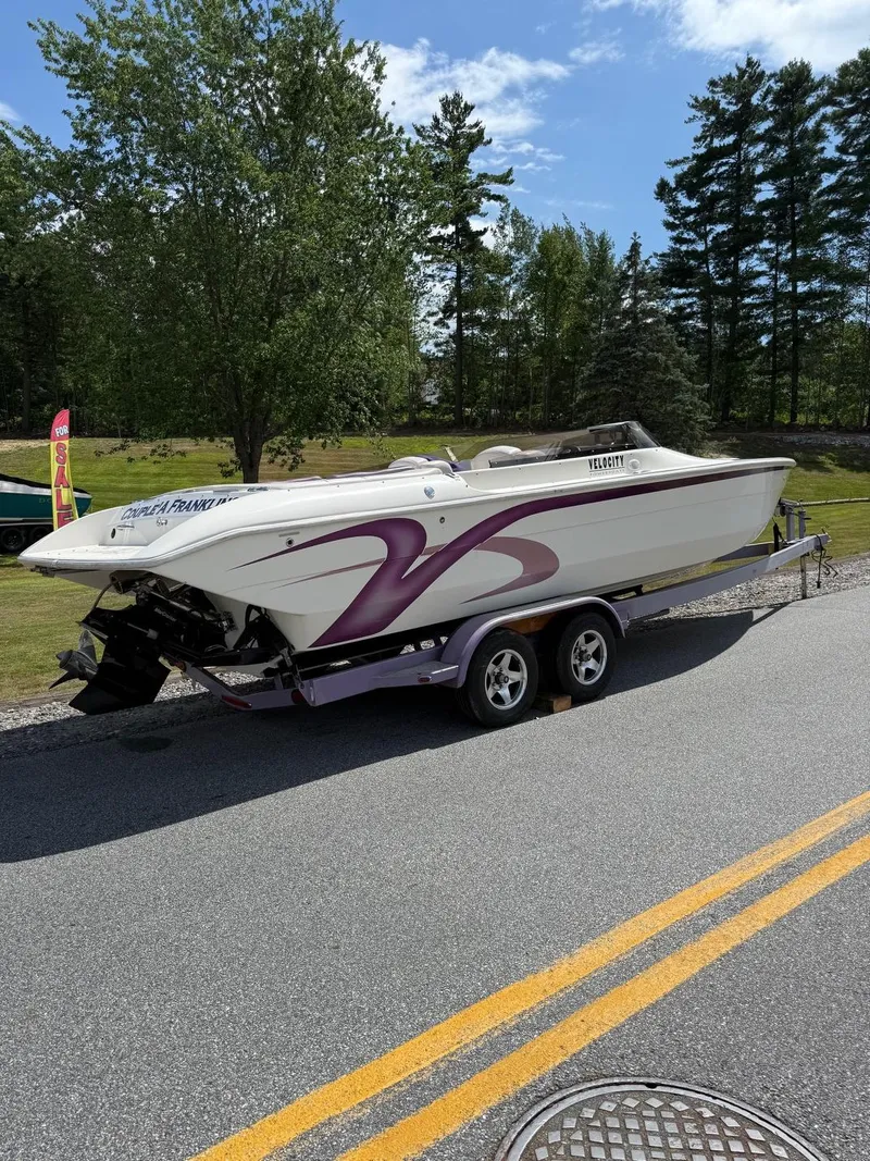 Slide: The Image of 2006 Velocity VR1 speedboat on trailer, parked on road, surrounded by trees. - 3