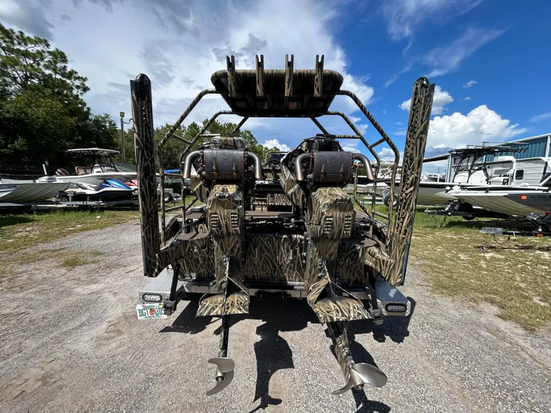 Slide: The Image of Camouflage-patterned Prodigy 2070 boat, 2023 model, with dual motors, parked outdoors under a blue sky. - 3