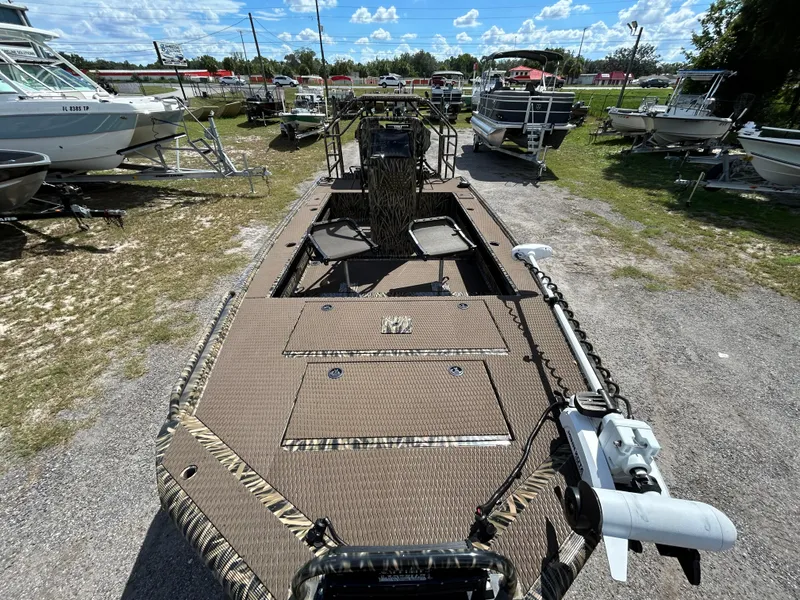 Slide: The Image of Prodigy 2070 boat, 2023 model, parked outdoors with other boats under a blue sky. - 7