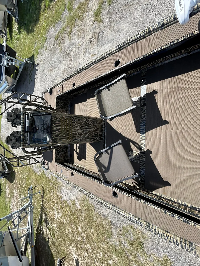 Slide: The Image of 2023 Prodigy 2070 boat with camouflage design and seating, parked on grass. - 8