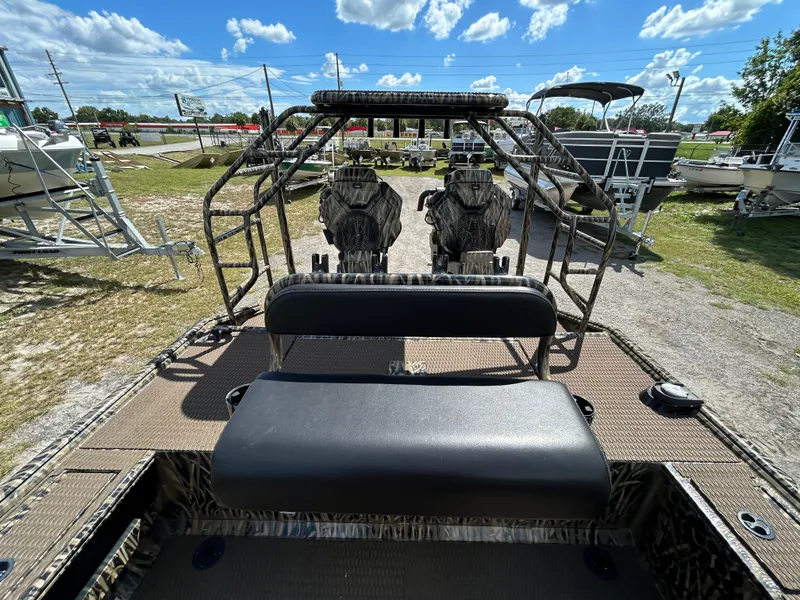 Slide: The Image of 2023 Prodigy 2070 boat interior with seating, camo design, and clear sky background. - 9