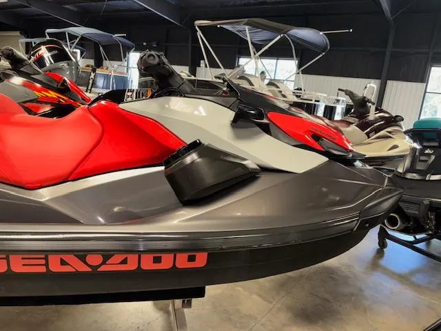 Slide: The Image of 2023 Sea-Doo GTI SE jet ski with red and gray design in showroom. - 15