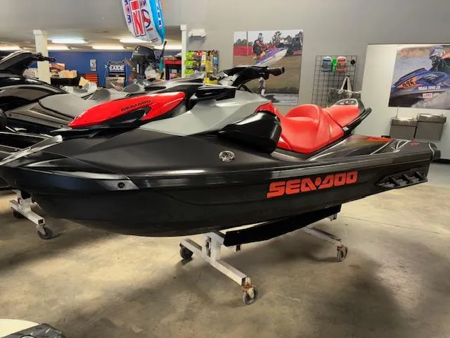 Slide: The Image of 2023 Sea-Doo GTI SE jet ski in showroom, black and red design. - 3