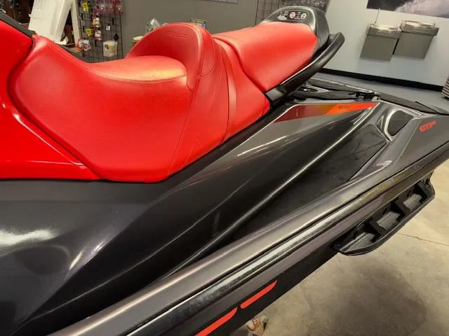 Slide: The Image of 2023 Sea-Doo GTI SE with red seat and sleek black design in showroom. - 5