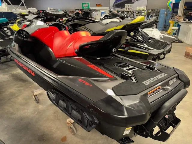 Slide: The Image of 2023 Sea-Doo GTI SE jet ski with red and black design in showroom. - 6