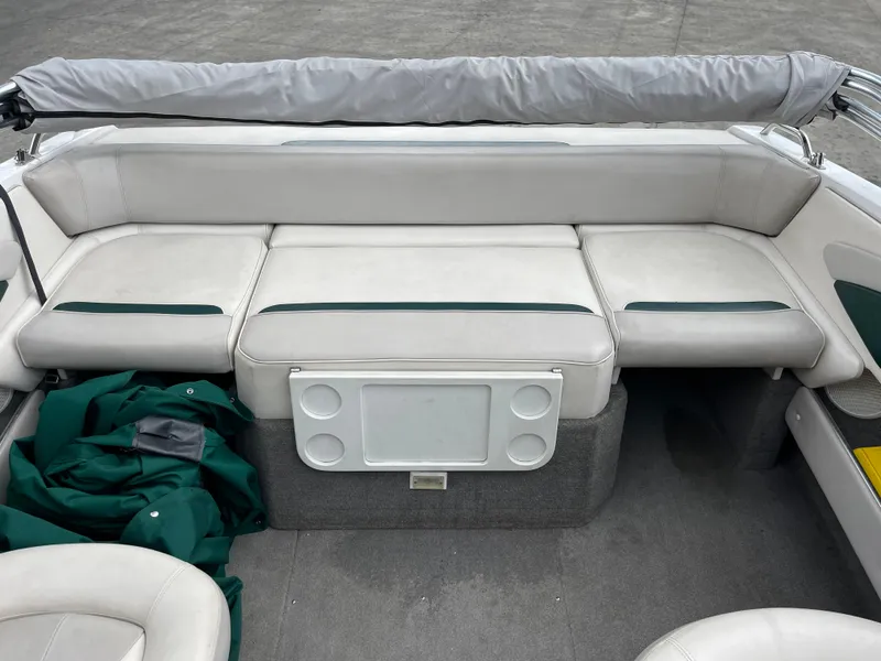 Slide: The Image of 1995 Four Winns 240 Horizon boat interior with white seating and green accents. - 10