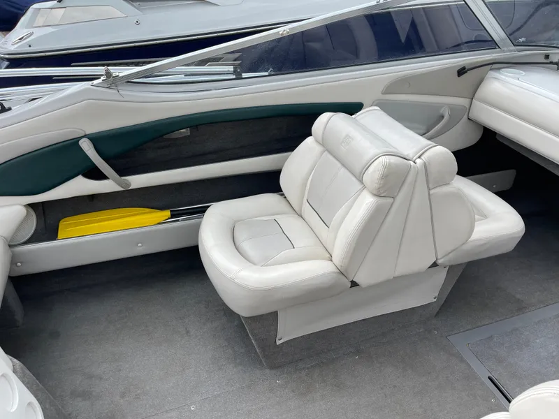 Slide: The Image of Interior of a 1995 Four Winns 240 Horizon boat with white seating and carpeted floor. - 12