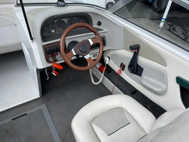 Slide: The Image of 1995 Four Winns 240 Horizon boat interior with steering wheel and dashboard controls. - 13
