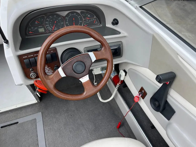 Slide: The Image of 1995 Four Winns 240 Horizon boat dashboard with wood steering wheel and instrument panel. - 14