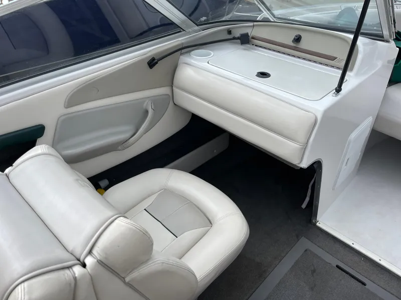 Slide: The Image of Interior of a 1995 Four Winns 240 Horizon boat with white seating and dashboard. - 15