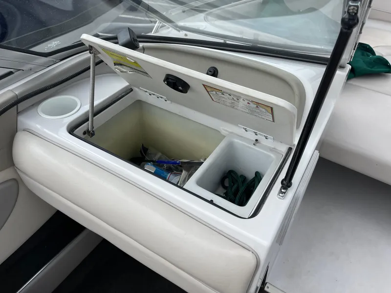 Slide: The Image of Open storage compartment on a 1995 Four Winns 240 Horizon boat, showing interior contents. - 16