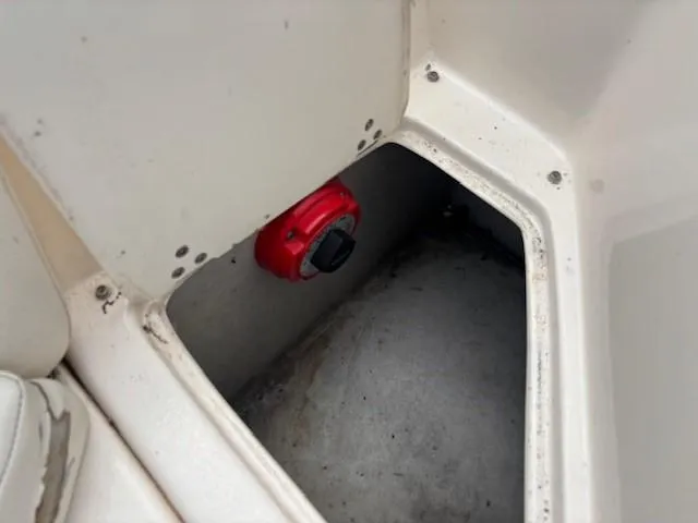 Slide: The Image of Storage compartment in a 2006 Rinker 232 Captiva Bowrider boat with a red switch. - 13
