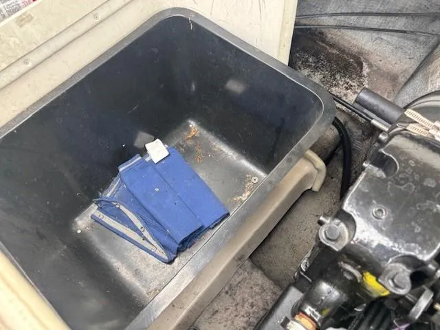 Slide: The Image of Storage compartment in a 2006 Rinker 232 Captiva Bowrider boat with a blue item inside. - 16