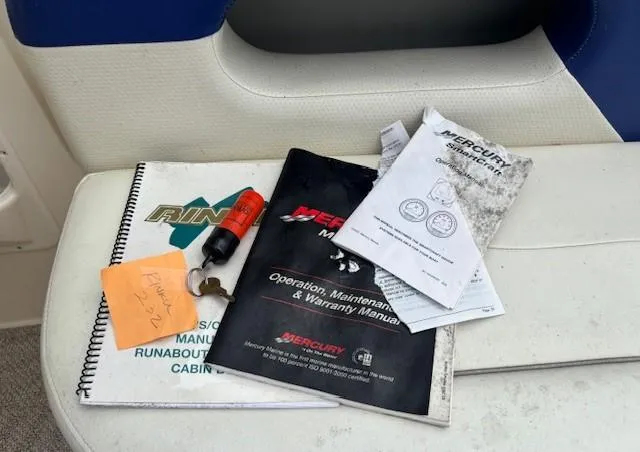Slide: The Image of Manuals and keys for 2006 Rinker 232 Captiva Bowrider on boat seat. - 18