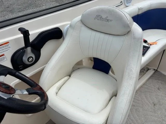 Slide: The Image of 2006 Rinker 232 Captiva Bowrider interior with white captain's seat and steering wheel. - 19