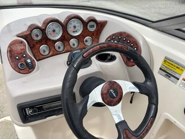 Slide: The Image of Dashboard of a 2006 Rinker 232 Captiva Bowrider with wood accents and steering wheel. - 20