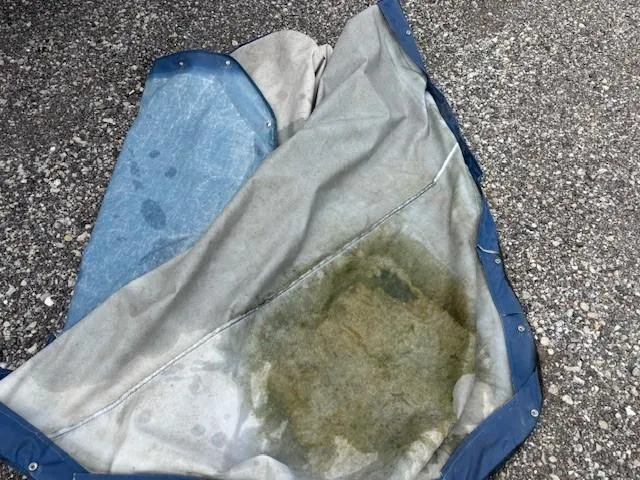 Slide: The Image of Dirty boat cover on pavement, possibly from a 2006 Rinker 232 Captiva Bowrider. - 21