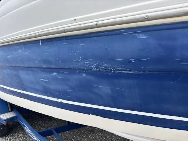 Slide: The Image of 2006 Rinker 232 Captiva Bowrider with visible scratches on blue hull. - 30
